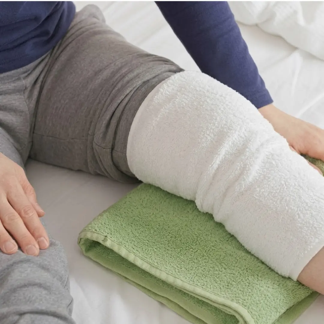 Kühlen mit einem feuchten Wickel nach Knie Operation